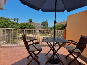 una mesa con 2 sillas y una sombrilla en el patio en Panorama, en Torrox Costa