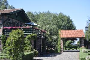a building with a gate and flowers on it at Lisia Góra nad jeziorem Łebsko in Izbica