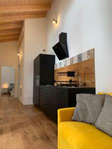 Una sala de estar con un sofá amarillo y una cocina. en Arco Holiday, en Arco