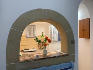 eine Küche mit einer Blumenvase auf dem Tisch in der Unterkunft Patmos Maria Studios in Skala