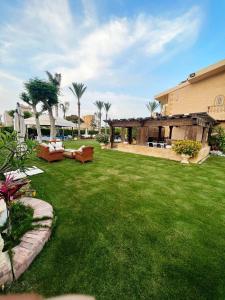 um jardim verde com um edifício e um relvado com em قصر علي لسان الوزراء مارينا العلمين مطروح em El Alamein