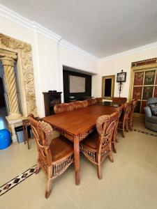 uma sala de jantar com uma mesa de madeira e cadeiras em قصر علي لسان الوزراء مارينا العلمين مطروح em El Alamein