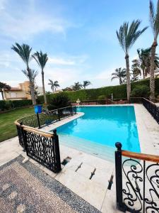 uma grande piscina com palmeiras ao fundo em قصر علي لسان الوزراء مارينا العلمين مطروح em El Alamein