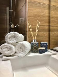 a bathroom with towels and candles on a shelf at A&C Cozy apartment Elvas in Elvas