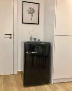 a black refrigerator in a room next to a door at A&C Cozy apartment Elvas in Elvas