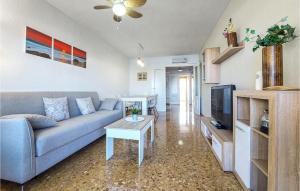 a living room with a blue couch and a tv at Amazing Apartment In El Puig De Santa Maria With Kitchen in La Torre