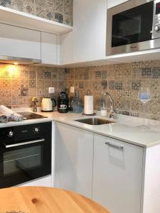 uma cozinha com um lavatório e um fogão forno superior em A&C Cozy apartment Elvas em Elvas