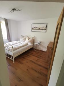 Habitación blanca con cama y espejo en Appartement Sonnenrot, en Sankt Lorenzen ob Murau