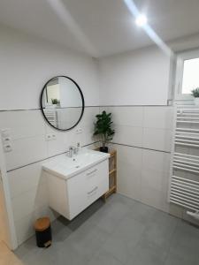Baño blanco con lavabo y espejo en Appartement Sonnenrot, en Sankt Lorenzen ob Murau