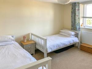 a bedroom with two twin beds and a window at Alma Cottage in Axminster