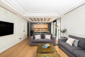 a living room with two couches and a tv at Apartamentos La Zagalilla in Málaga