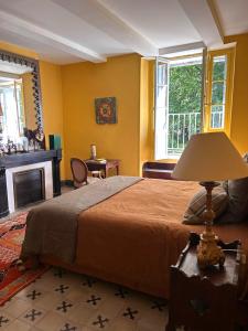 a bedroom with a bed and a table with a lamp at Château La Bruguière in Tornac