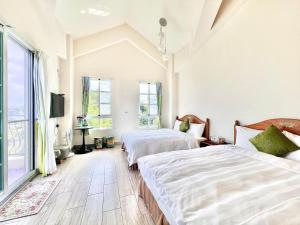 a bedroom with two beds and a tv at 台東普羅旺斯莊園民宿 Provence Inn in Taitung City