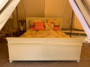 een wit bed met kussens in een tent bij Eco Glamping. Private luxury tent in Alfambras. in Aljezur