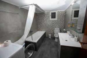 a bathroom with a tub and a toilet and a sink at Harmony Apartment Kavala in Kavala