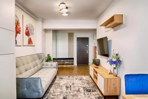 a living room with a couch and a tv at Apartament Kenya in Bacău