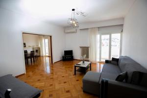 Harmony Apartment Kavala في كافالا: غرفة معيشة مع أريكة وطاولة
