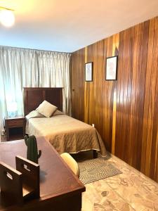 a bedroom with a bed with wooden walls and a table at Casa Tigris in Mexico City +68 photos