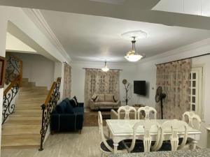 uma sala de estar com uma mesa e cadeiras e um sofá em فيلا برايفت بول في مارينا الساحل الشمالي em El Alamein