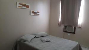 Schlafzimmer mit einem Bett mit einem Tisch und einem Fenster in der Unterkunft Casa Guarus in Campos dos Goytacazes