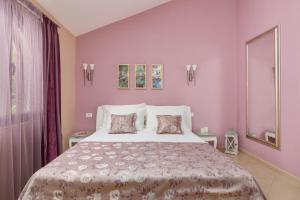 - une chambre avec un grand lit aux murs violets dans l'établissement Apartments Djuranovic, à Kotor