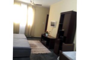 1 dormitorio con 1 cama, vestidor y TV en Casa Guarus, en Campos dos Goytacazes