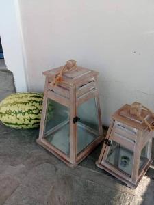 two wooden boxes sitting on the ground next to a wall at Seaside resort / Lemnos 