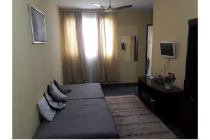 Schlafzimmer mit einem Bett und einem Fenster mit einem TV in der Unterkunft Casa Guarus in Campos dos Goytacazes