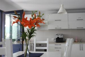 a vase with orange flowers on a table in a kitchen at Vila Selina in Eşelniţa