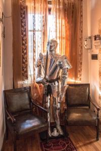 a metal robot sitting between two chairs in a room at B&B Camelot in Palermo