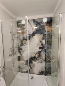 a shower with a glass door in a bathroom at Apartman Gallery Freya in Zadar