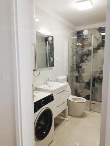 a bathroom with a washing machine and a toilet at Apartman Gallery Freya in Zadar
