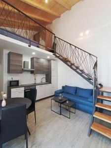 a living room with a blue couch and a staircase at Apartman Gallery Freya in Zadar