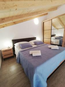 a bedroom with a large bed with two towels on it at Apartman Gallery Freya in Zadar