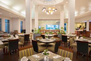 a restaurant with tables and chairs and a chandelier at Krystal Urban Monterrey San Jeronimo in Monterrey