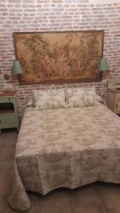 um quarto com uma cama grande e uma parede de tijolos em La Posada del Canario em Cangas de Onís
