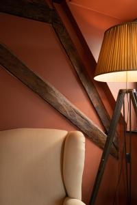 a lamp and a chair in a room at Guest House La Civière d'or in Bruges