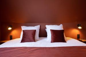 a bedroom with a bed with two red and white pillows at Guest House La Civière d'or in Bruges