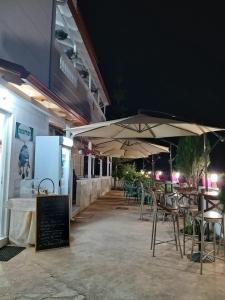 Villa Sarti في كساميل: مطعم بطاولات وكراسي ومظلات في الليل
