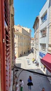 a group of people walking down a city street at City Center Lodge in Pula +22 photos