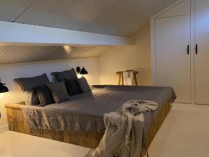 een slaapkamer met een groot bed in een kamer bij Stijlvol huisje met veranda! Tuynloodz A in Beers