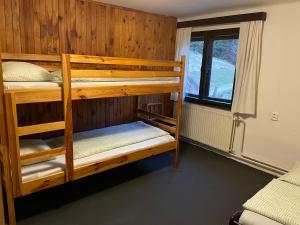two bunk beds in a room with a window at Chata Barbora in Lučany nad Nisou