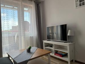 a living room with a television and a coffee table at Bursztynek in Hel