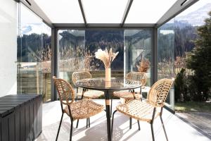 a patio with a table and chairs on a balcony at Chalet Casita in Engelberg