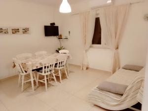 a white dining room with a table and chairs at Marin in Šibenik