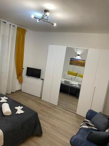ein Wohnzimmer mit einem Bett und einem Spiegel in der Unterkunft Savonarola Almarc 2 in Alessandria