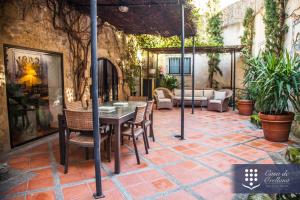 a patio with a table and chairs on a brick floor at Hotel Boutique Casa de Orellana in Trujillo