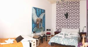 Un dormitorio con una cama y un cuadro en la pared. en B&B Camelot, en Palermo