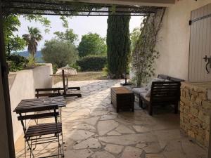 a patio with chairs and a couch and a table at A casa dolce in Le Castellet