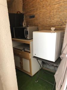 a small kitchen with a microwave and a refrigerator at A casa dolce in Le Castellet